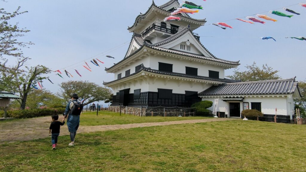 城山公園にこいのぼりの装飾がされたお城を楽しむ親子